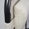 Close-up of the armrest and woven seat of a chair. Produktbild-Vorschau