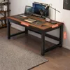 A desk with a laptop, monitor, and lamp on it, placed on a wooden floor with a rug in front. Produktbild-Vorschau