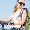 A young woman riding a bicycle with a backpack. Produktbild-Vorschau