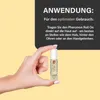 A hand holding a small roll-on perfume bottle with instructions on how to use it. Produktbild-Vorschau
