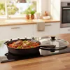 A cast iron pan with food is on a modern induction stovetop in a kitchen. Náhled obrázku produktu