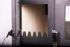 A close-up view of the interior of a wood-burning stove, showing a metal grate and a light brown panel. Produktbild-Vorschau