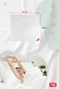 A woman stretching in bed with a duvet and pillows. Produktbild-Vorschau