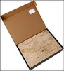 A cardboard box is open, revealing a flat wooden sheet with laser-cut pieces for a marble run kit. Voir les images du produit