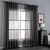A window with dark gray sheer curtains hanging on a curtain rod. Produktbild-Vorschau