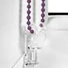 A close-up of a purple beaded chain and a clear plastic bracket for a roller blind. Produktbild-Vorschau