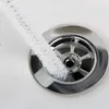 A white cleaning brush is shown being used to clean a sink drain. Produktbild-Vorschau