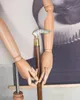 A close-up shot of a wooden cane held by a mannequin's hands. Náhľad obrázku produktu
