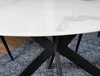 Close-up of a round dining table with a white marble-patterned top and a black metal base, placed on a blue patterned rug. Anteprima dell’immagine prodotto
