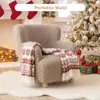 A child's armchair with a festive throw blanket is placed in a cozy, Christmas-themed room with a fireplace and a decorated tree. Produktbild-Vorschau