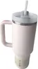 A close-up studio shot of a cream-colored insulated tumbler with a pink handle and a white lid with a straw. Podgląd zdjęcia produktu
