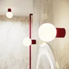 A modern interior with a marble-patterned wall, featuring several red and white wall lights. Produktbild-Vorschau