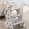 A close-up view of a white and gray plastic children's slide with a rocket design, showing the steps and side supports. Náhled obrázku produktu