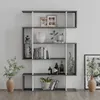A modern, multi-level bookshelf unit with various decorative items and books displayed on its shelves, set against a plain white wall. Produktbild-Vorschau