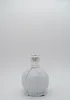 A bottle of liqueur wrapped in white paper, with a label on the neck. Produktbild-Vorschau