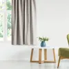 A light beige curtain hangs next to a window, with a small white table and a green chair in the foreground. Produktbild-Vorschau