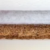 A close-up view of a layered mattress material, showing different textures and materials. Produktbild-Vorschau