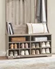 A wooden shoe rack with storage shelves and hooks, featuring shoes, books, a basket, and a pillow. Náhled obrázku produktu
