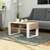 A coffee table in a living room setting, next to a sofa and a floor lamp. Voir les images du produit