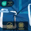 A close-up of blue and white patterned fabric, likely bedding, with marketing badges and text overlays. Produktbild-Vorschau
