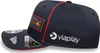 A close-up side view of a navy blue baseball cap with red trim and logos. Náhled obrázku produktu