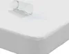 A close-up view of a white mattress protector with a glass of water spilled on it, demonstrating its waterproof feature. Voir les images du produit