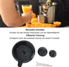 A person is holding a glass of orange juice next to a juicer and oranges. Produktbild-Vorschau