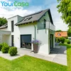 A modern house with a rain barrel in the garden. Produktbild-Vorschau