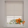 A roller blind is shown covering the top half of a window, with a vase of orange tulips on the windowsill below. Produktbild-Vorschau