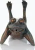 A bronze-colored garden figurine of a frog lying on its back with its arms and legs in the air. Produktbild-Vorschau