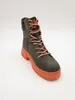 A single green and orange lace-up boot is shown against a white background. Produktbild-Vorschau