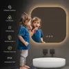 A young child brushing their teeth in front of a lit LED bathroom mirror. Podgląd zdjęcia produktu