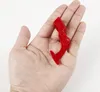 A red plastic tool is held in a person's palm against a white background. Produktbild-Vorschau