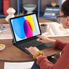 A person is using a tablet with a keyboard attached on a wooden table. Podgląd zdjęcia produktu