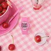 A pink Baby-G watch is placed on a pink checkered tablecloth next to cherries and a small white cup. Produktbild-Vorschau