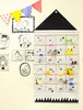 A fabric advent calendar with 24 pockets hanging on a wall, decorated with drawings and a banner. Podgląd zdjęcia produktu