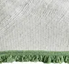 Close-up view of the underside of a green rug or mat with fringe. Produktbild-Vorschau