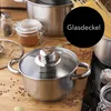 A close-up shot of a stainless steel pot with a glass lid, surrounded by ingredients like garlic, spices, and pasta, suggesting a cooking context. Náhľad obrázku produktu
