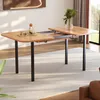 A wooden dining table with extendable leaves, set in a well-lit room with a rug and a window in the background. Náhľad obrázku produktu