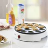 A white mini pancake maker with 10 mini pancakes in it, placed on a white table with cooking ingredients in the background. Náhľad obrázku produktu