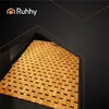 A bamboo bath mat is shown on a dark surface, with abstract geometric lines in the background. Anteprima dell’immagine prodotto