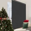 A Christmas tree decorated with ornaments and candy canes stands next to a dark gray vertical blind in a room with two decorative pillows on a stool. Náhled obrázku produktu