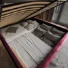 The image shows the storage space of an open bed frame, filled with pillows and bedding. Produktbild-Vorschau