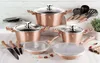 A collection of rose gold cookware and knives arranged on a white surface with a brick-patterned background. Anteprima dell’immagine prodotto