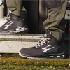A person wearing work pants and safety shoes is standing on a step. Produktbild-Vorschau