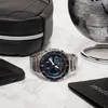A watch, passport, phone, and bag are arranged on a marble surface, suggesting travel. Produktbild-Vorschau