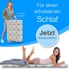 A woman is holding a folded mattress, and another woman is lying on a mattress. Produktbild-Vorschau