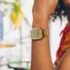 A close-up shot of a person's arm wearing a gold digital watch. Podgląd zdjęcia produktu