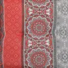 A close-up view of a patterned fabric, likely a cushion cover or upholstery, with a repeating mandala-like design in red and gray on a white background. Produktbild-Vorschau
