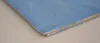 A close-up of the edge of a flat, rectangular object, likely a stove plate or similar item, resting on a textured surface. Produktbild-Vorschau